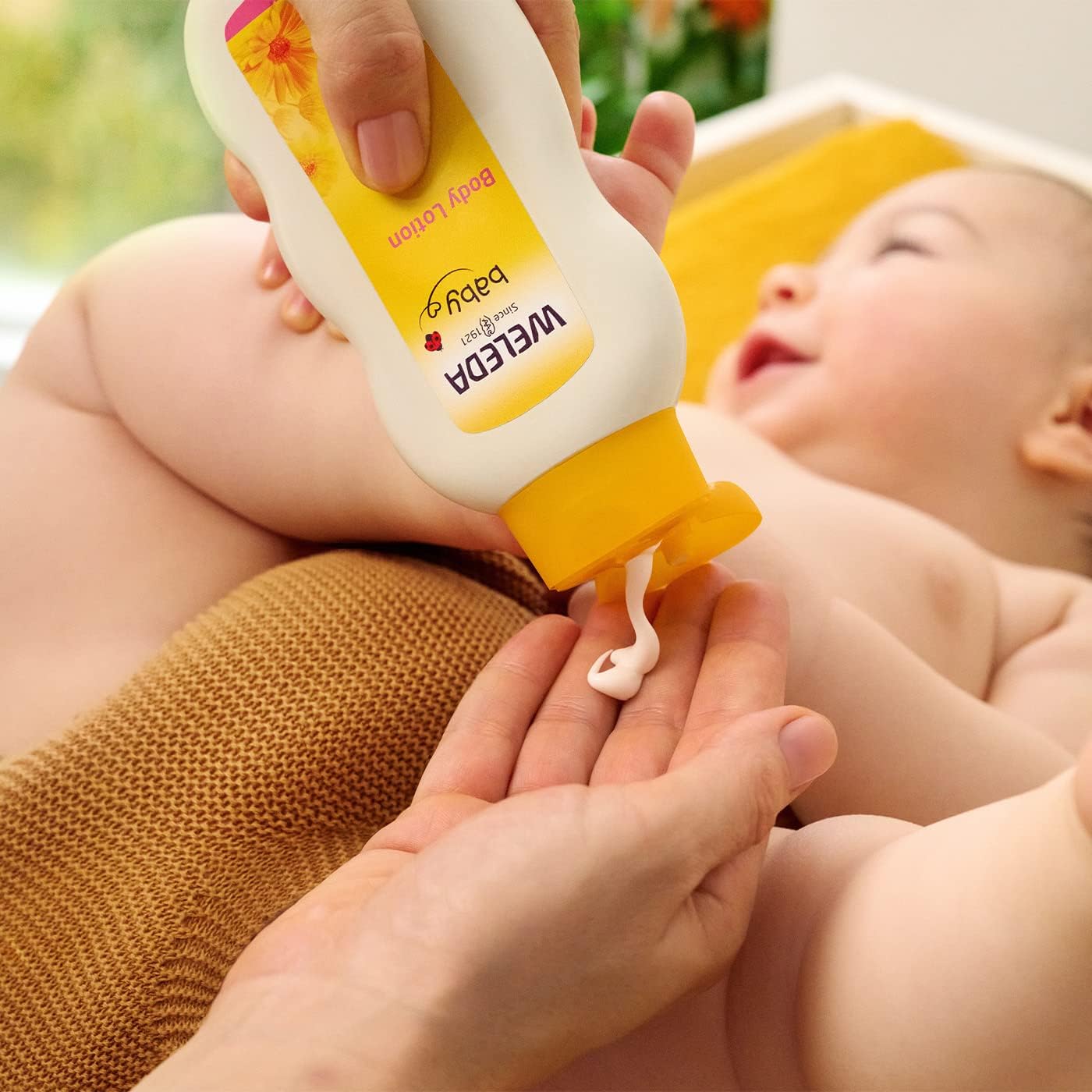 Image showing Weleda Baby  Body Lotion product about to apply to baby